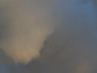 Wolkenhaufen über goldgelb angeleuchteten Scheibenwand